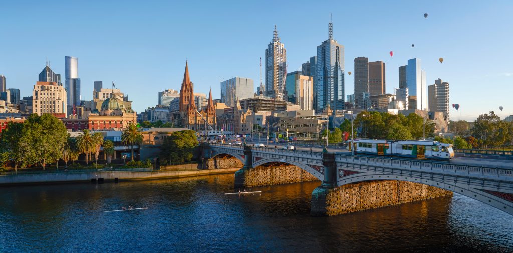 Yarra river with a tram on a bridge with Melbourne CBD in the background